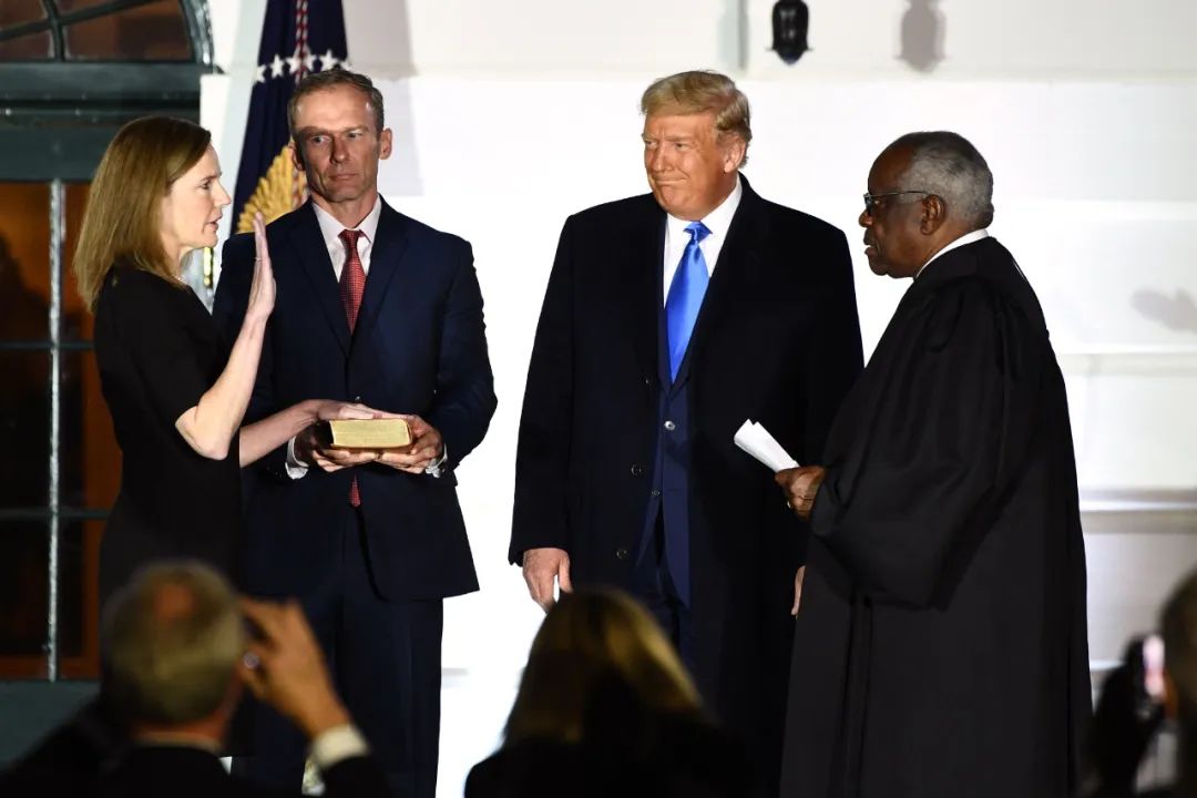 2020年10月，托马斯（右一）与特朗普出席大法官艾米·科尼·巴雷特（左一）的宣誓就职典礼。图源：美媒